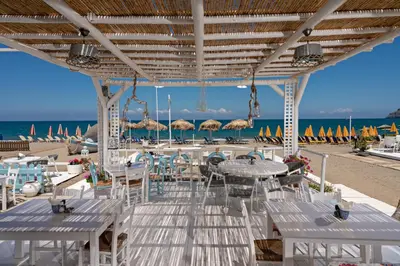 a restaurant on the beach with tables and chairs at Sonio Beach - Que Bella Collection in Plataniás