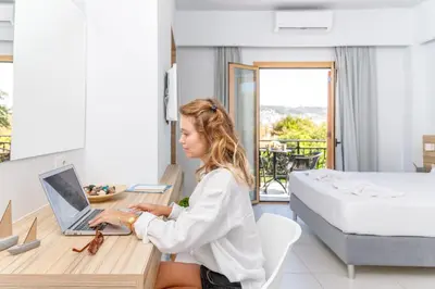 a woman sitting at a desk with a laptop at Notus Chania Crete in Chania Town