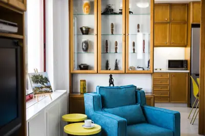 a living room with a blue chair and a table at La Vita Moderna in Chania Town