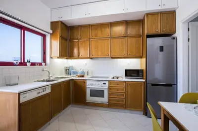 a kitchen with wooden cabinets and a stainless steel refrigerator at La Vita Moderna in Chania Town