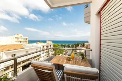 a balcony with a table and chairs and the ocean at La Vita Moderna in Chania Town