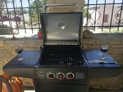 a gas grill with two glasses of red wine at Mansion Rokka in Kissamos