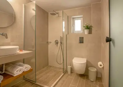 a bathroom with a shower and a toilet and a sink at Castro Beach Hotel in Maleme