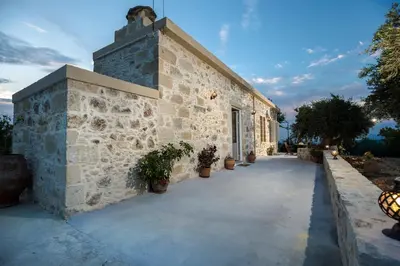 a stone building with potted plants on it at Margarita's Stone House in Plátanos