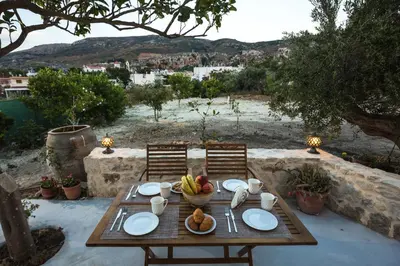 a wooden table with a bowl of fruit on it at Margarita's Stone House in Plátanos