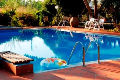 a swimming pool with a bench and a swimming pool at Kalives Apartments in Kalyves