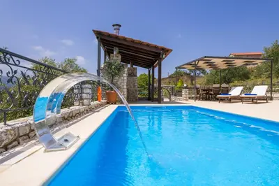 a pool with a water fountain in a backyard at Casa Magnolia in Katokhórion