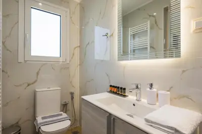 a bathroom with a sink and a toilet and a mirror at Casa Magnolia in Katokhórion