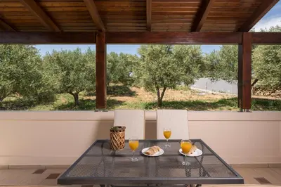 a table with two chairs and two glasses of orange juice at Casa Magnolia in Katokhórion
