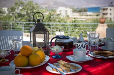 a table with plates of food on a red table cloth at Villa Alexandra in Kissamos
