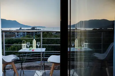 a balcony with a table and chairs and a view of the ocean at Villa Alexandra in Kissamos