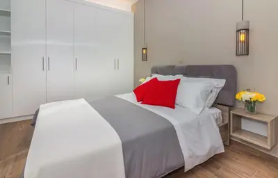 a bedroom with a large bed with red pillows at Olive Garden Holiday Home steps to Beach 1 in Kato Daratso