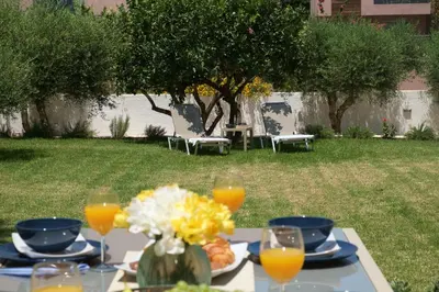 a table with a plate of food and orange juice at Olive Garden Holiday Home steps to Beach 1 in Kato Daratso
