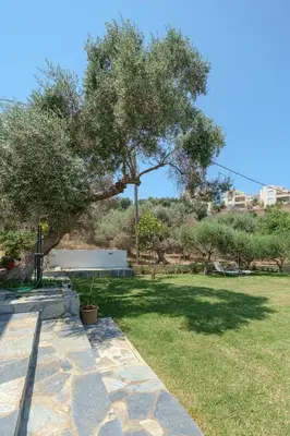 a park with a bench and a tree at Olive Garden Holiday Home steps to Beach 1 in Kato Daratso