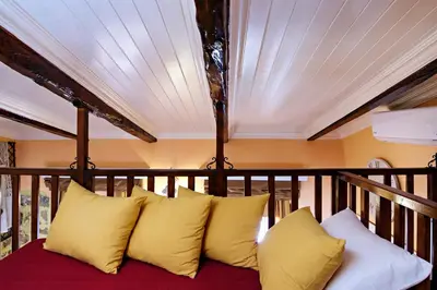 a couch on a balcony with yellow pillows at Sali Chelidonaki boutique suite in Chania Town