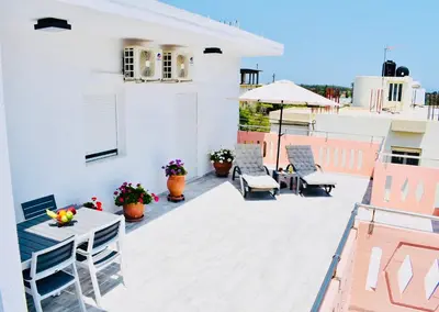a patio with a table and chairs on a roof at Cozy Renovated Apartment 