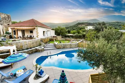 a swimming pool with chairs and a house at Zen Villa Elafonisi in Kamára