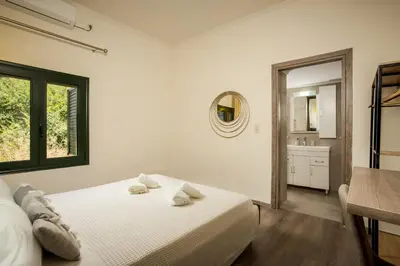 a white bedroom with a bed and a bathroom at Zen Villa Elafonisi in Kamára