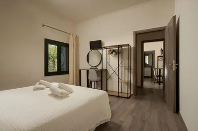 a bedroom with a white bed and a mirror at Zen Villa Elafonisi in Kamára