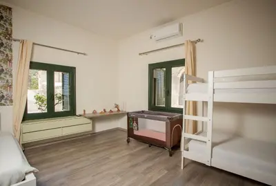 a bedroom with a bunk bed and two windows at Zen Villa Elafonisi in Kamára
