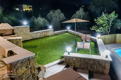 a garden with an umbrella and a lawn with a pool at Zen Villa Elafonisi in Kamára