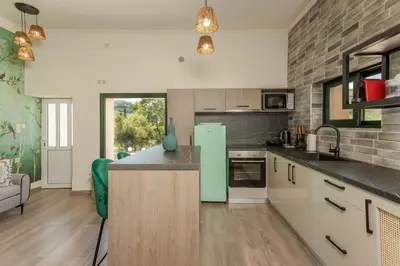 a kitchen with white cabinets and a green refrigerator at Zen Villa Elafonisi in Kamára