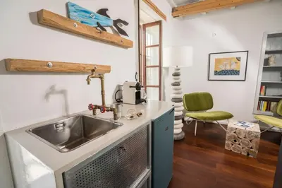 a kitchen with a sink and a green chair at kito- transformed house on the water's edge in Chania Town