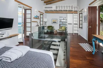 a living room with a glass table and a bed at kito- transformed house on the water's edge in Chania Town