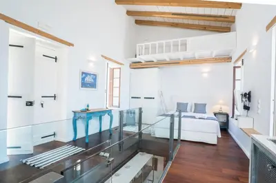 a large white room with a bed and a glass floor at kito- transformed house on the water's edge in Chania Town
