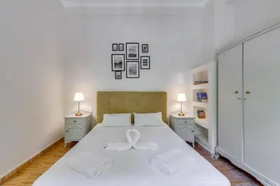 a bedroom with a white bed with a bow on it at Samouil Apartment steps from the beach in Chania Town
