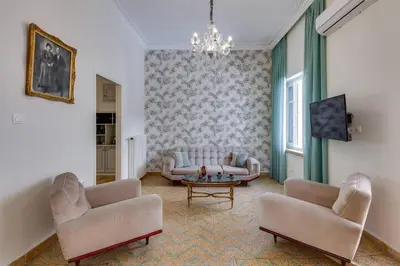 a living room with a couch and two chairs and a table at Samouil Apartment steps from the beach in Chania Town