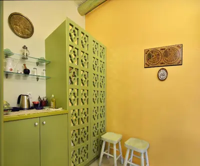 a kitchen with green and yellow walls with two stools at Casa della Favola Boutique Hotel in Chania Town