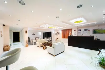 a large room with a lobby with white furniture at Golden Rose Suites in Kolymvari