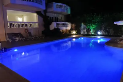 a swimming pool at night with blue lights at Golden Rose Suites in Kolymvari