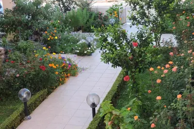 a garden with colorful flowers and a sidewalk at Golden Rose Suites in Kolymvari
