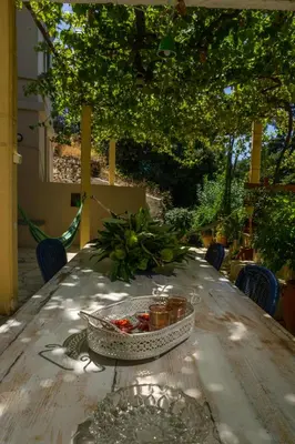 a wooden table with a bowl of fruit on it at Cottage home at South Chania in Grigorianá