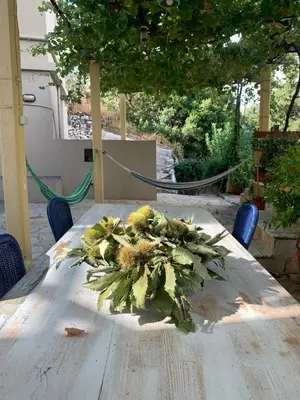 a wooden table with a flower arrangement on it at Cottage home at South Chania in Grigorianá