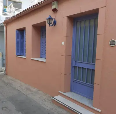 a building with a blue door and two windows at White Rose in Chania Town