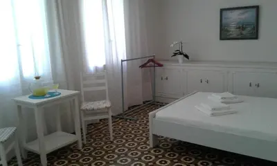 a white room with a bed and a table and window at White Rose in Chania Town