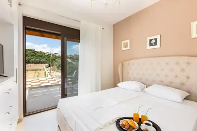 a bedroom with a bed with a view of a balcony at Eudora Luxury Stone Villa in Almirida