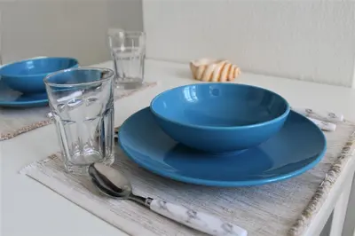 a table with two blue bowls and a glass at Dali Rooms in Chania Town