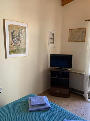 a bedroom with a bed and a tv in a room at Cozy one-bedroom apartment in Halepa, Chania in Chania Town