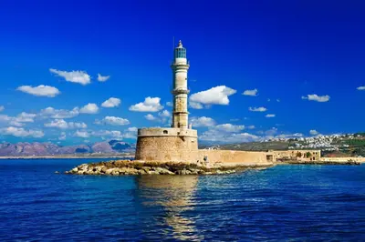 a lighthouse on a small island in the water at Cozy one-bedroom apartment in Halepa, Chania in Chania Town