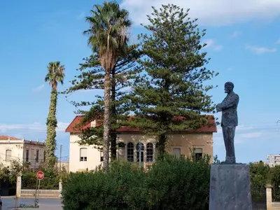 a statue of a man standing next to a tree at Cozy one-bedroom apartment in Halepa, Chania in Chania Town