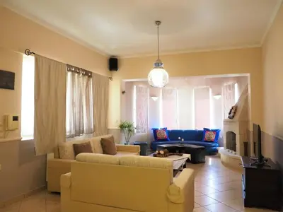 a living room with a couch and a table at Niko's art Villa in Chania in Perivólia