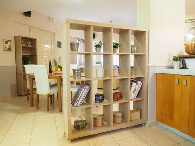 a book shelf in a kitchen with a table at Niko's art Villa in Chania in Perivólia