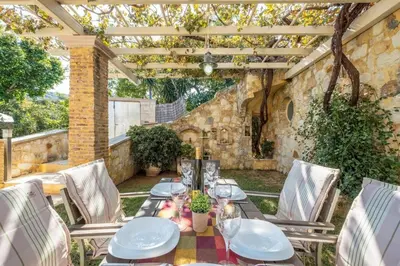 an outdoor dining table and chairs under a pergola at Niko's art Villa in Chania in Perivólia