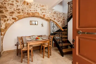 a dining room with a table and chairs and a staircase at Casa Emily in Chania Town