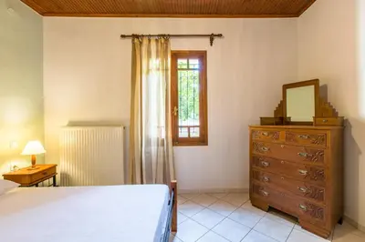 a bedroom with a bed and a dresser and a window at Femina in Pírgos Psilonérou