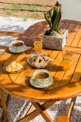 a wooden table with plates of food and drinks on it at Femina in Pírgos Psilonérou